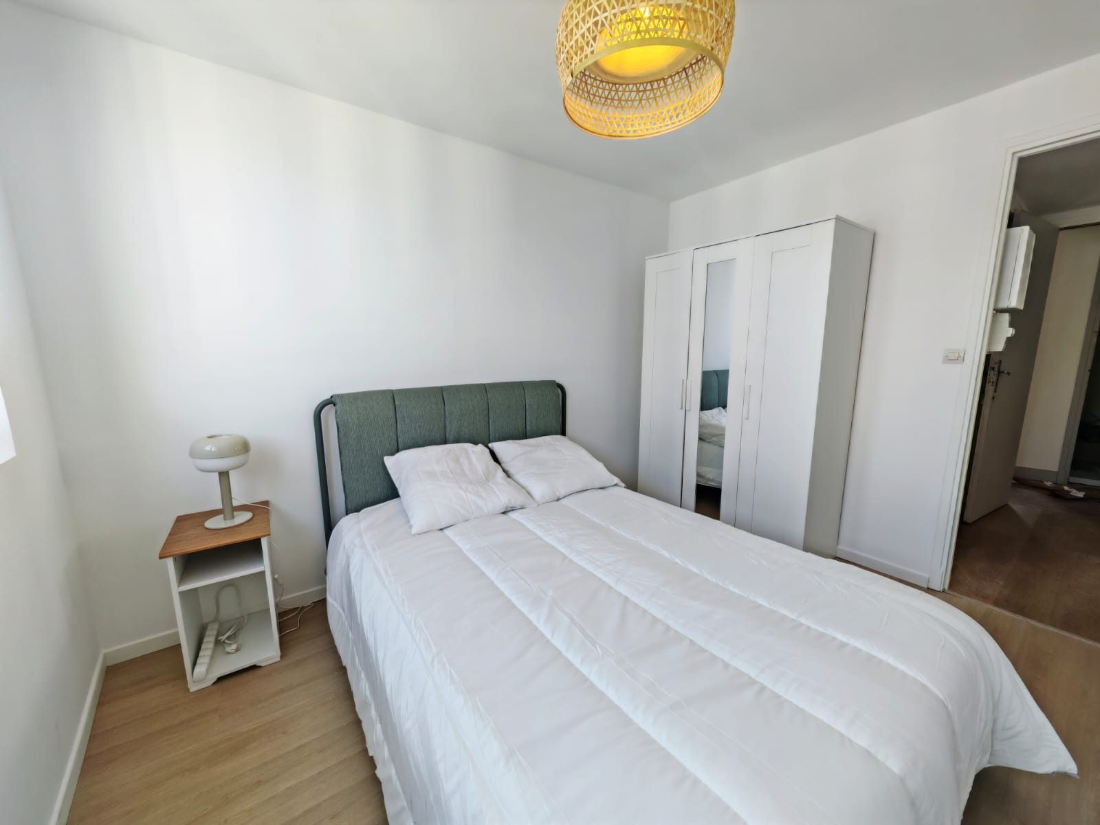 La chambre vue depuis la fenêtre, avec son armoire à portes miroir