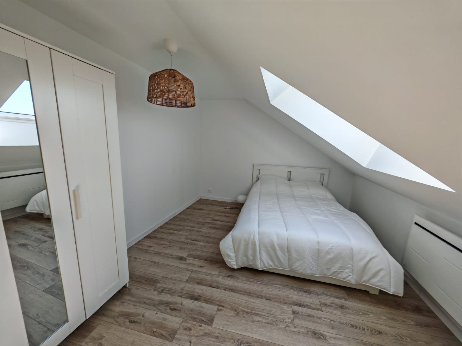 Chambre du T4 au Havre Danton avec armoire à miroir, vélux et parquet bois clair