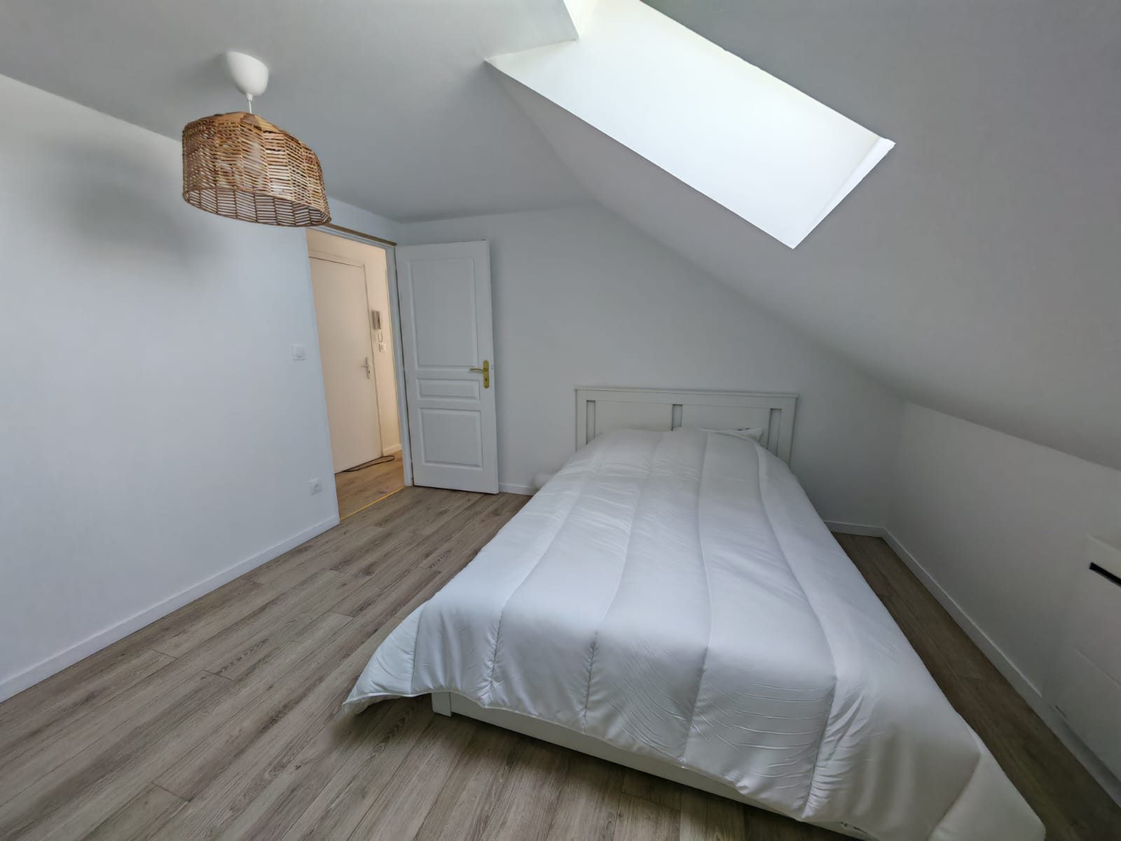 Chambre double du T4 au Havre Danton — grand vélux, parquet bois clair et suspension en rotin