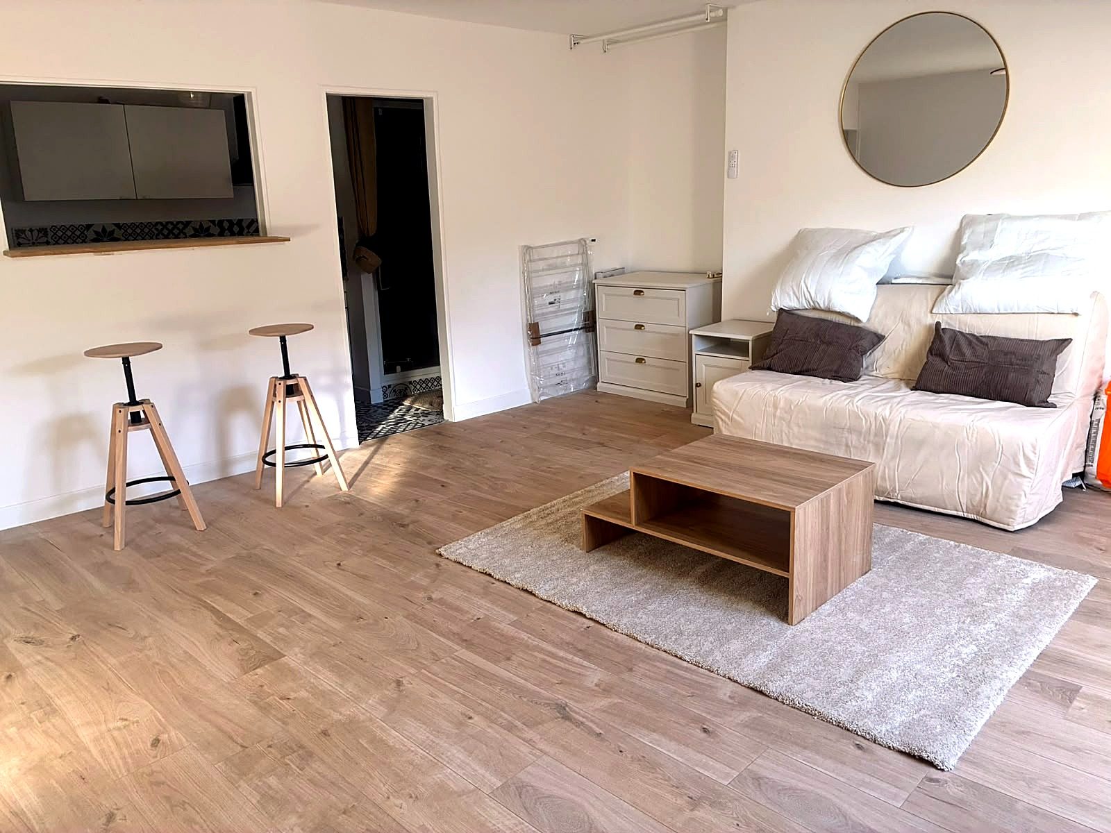 Coin repas avec tabourets de bar et passe-plat, appartement rénové dans le Vieux-Lille