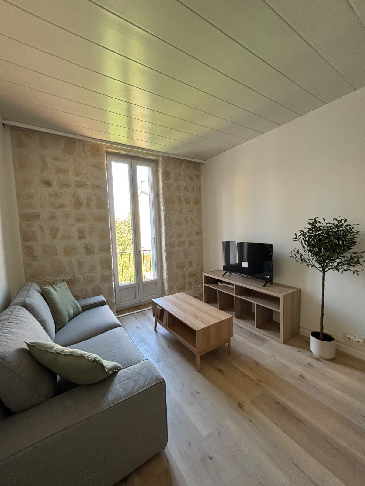 Le séjour vu depuis l’entrée, canapé, meuble télévision et sol neuf