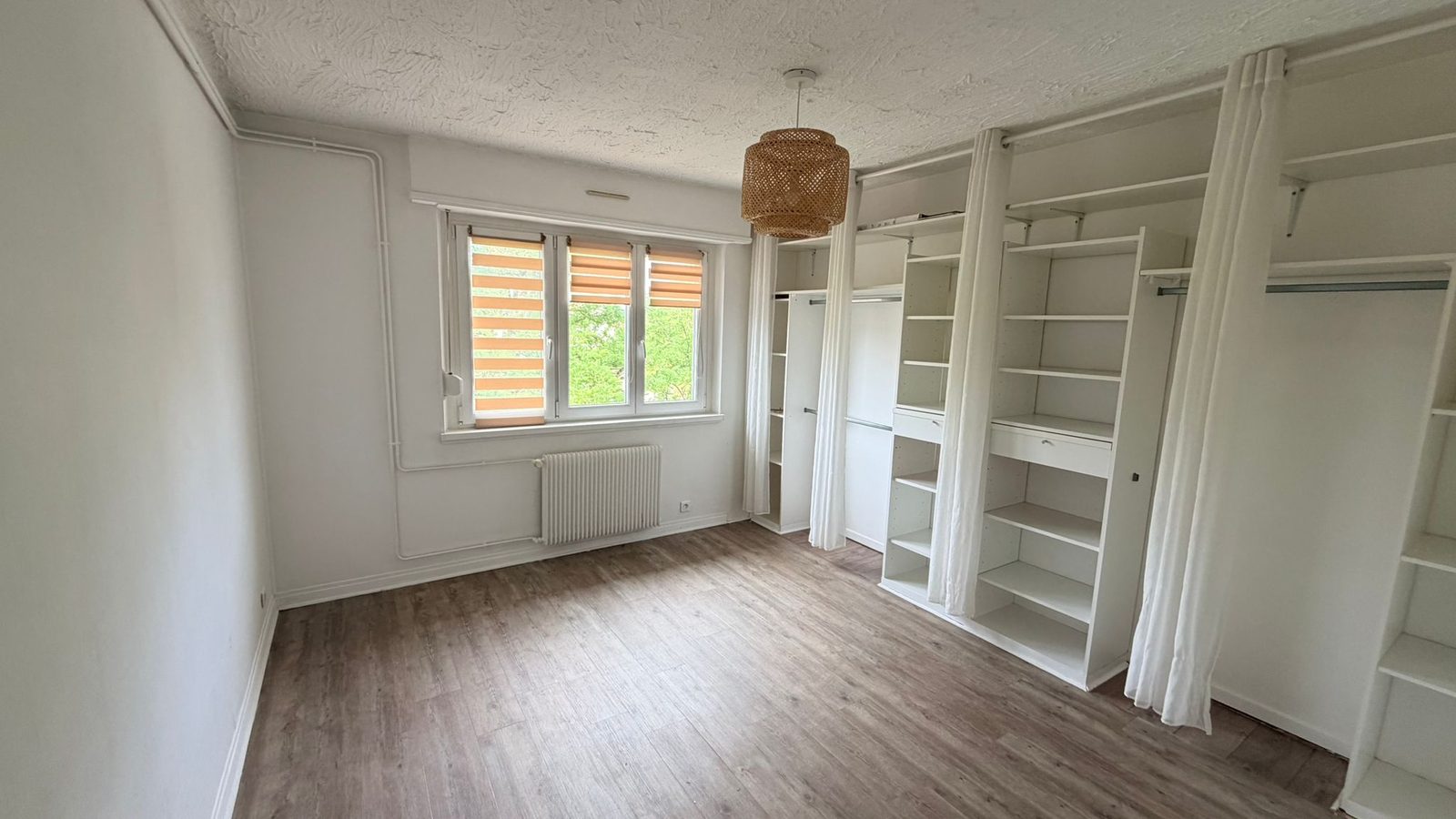 Chambre avec grand dressing intégré — étagères et penderies blanches sur mesure