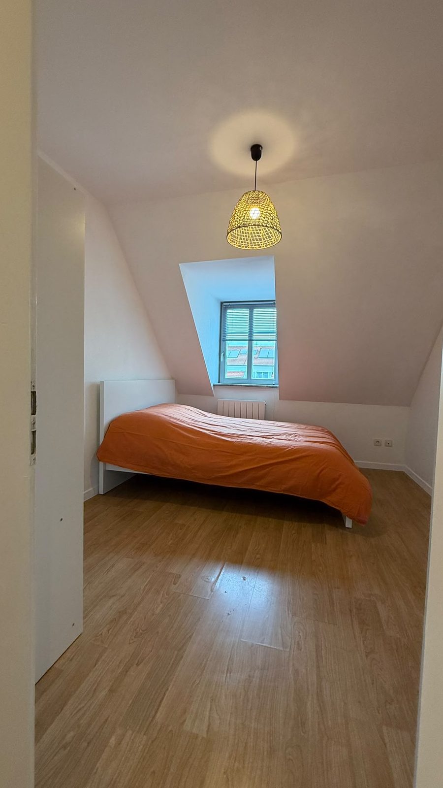 Chambre sous les toits avec lucarne, lit double et suspension tressée
