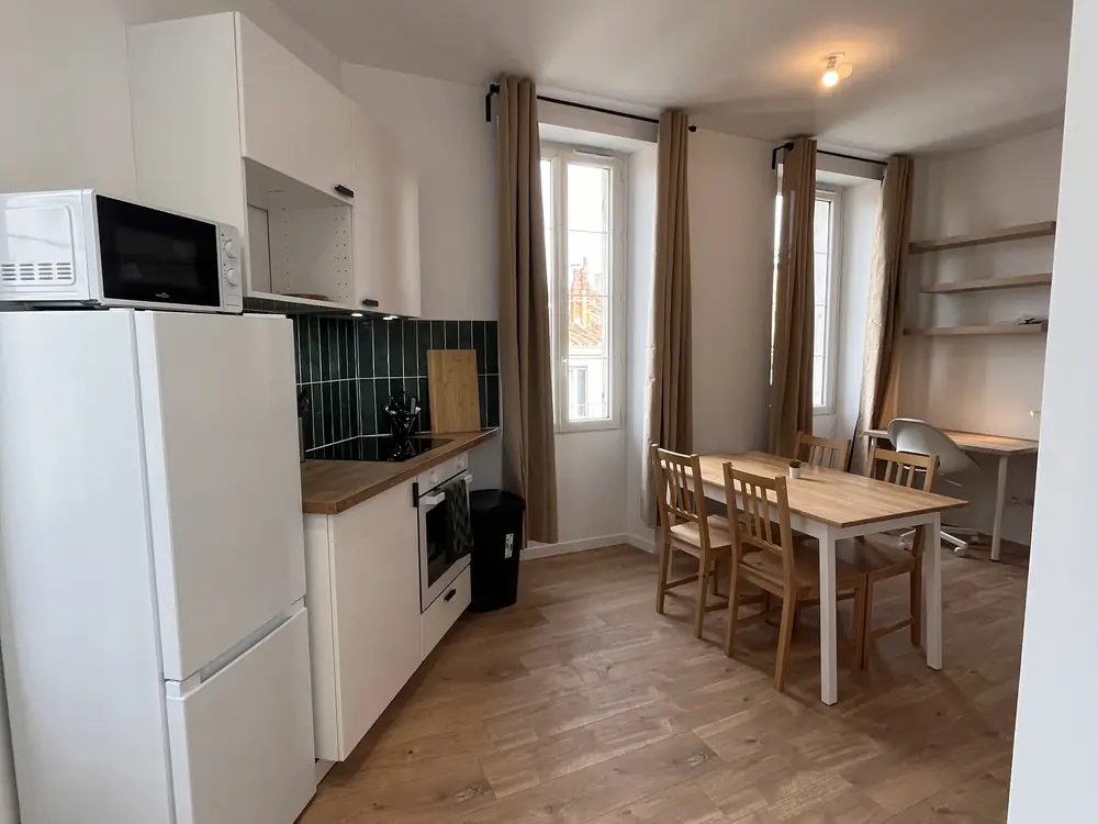 Après — cuisine ouverte refaite avec parquet et tabourets